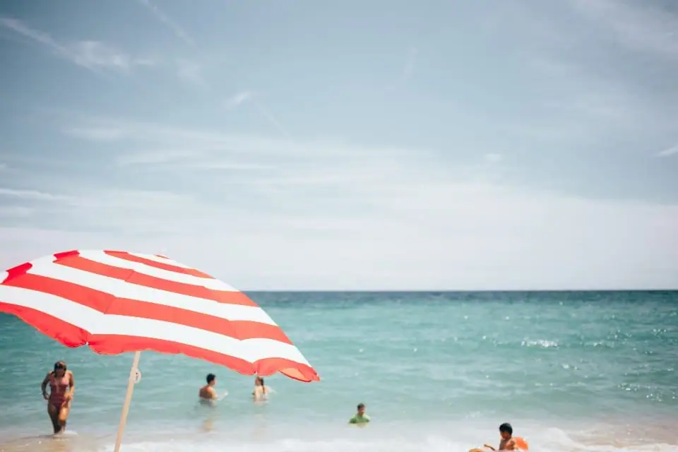 Guarda-sol listrado em praia de mar azul